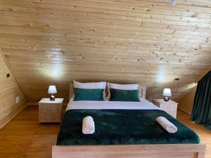 a bedroom with a large bed in a wooden ceiling at Guesthouse Demushi in Valbonë