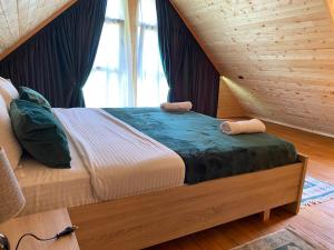 a bed in a wooden room with a large window at Guesthouse Demushi in Valbonë