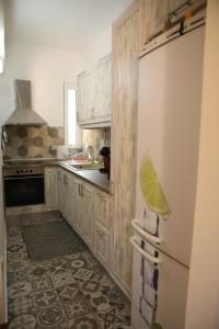 a kitchen with wooden cabinets and a white refrigerator at Casa Domenica in Corfu Town +11 photos