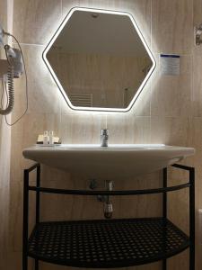 lavabo en el baño con espejo grande en la pared en Hotel Suites Feria de Madrid, en Madrid 21 fotos más