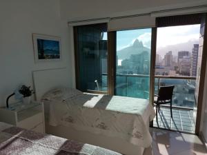 Un dormitorio con una cama y vistas a una ciudad. en TIFFANYs RIO FLAT, en Río de Janeiro
