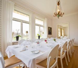 a large dining room with white tables and white chairs at Sure Hotel by Best Western Ojaby Herrgard in Växjö
