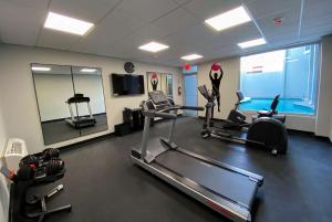 a gym with several treadmills and a swimming pool at TRYP by Wyndham Mayaguez in Mayaguez