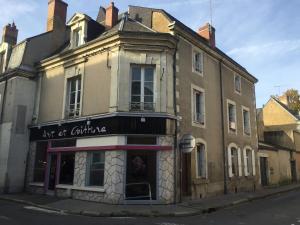 a building with a woman in the window of it at LES COTTAGES DU PRYTANEE in La Flèche