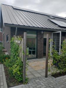 a house with a metal roof and a patio at The Two Branches 