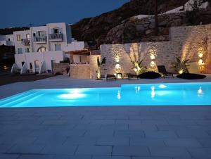 a swimming pool in front of a villa at night at Plaka's house seaside view in Plaka
