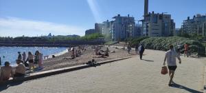 eine Gruppe von Menschen an einem Strand in der Nähe des Wassers in der Unterkunft A luxurious aprtm with a sauna and terrace Netflix in Helsinki