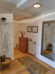 uma sala de estar com um espelho e uma cómoda em Das Hideaway zum Seele baumeln lassen ! em Bad Münstereifel