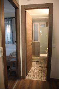 a bathroom with a door open to a bedroom at Casa Domenica in Corfu Town