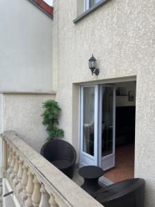uma varanda com 2 cadeiras e uma porta de vidro deslizante em Proche Paris et Disney Maison 90 M2 CLIMATISÉ bord de Marne em Gournay-sur-Marne