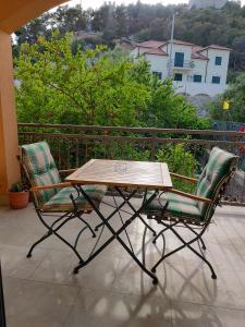 赫瓦爾的住宿－Udobna soba za dvoje，阳台上配有一张木桌和两把椅子