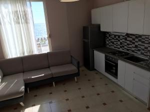 a kitchen with a couch and a stove top oven at Sea View Apartment Shkëmbi i Kavajes in Durrës