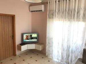 un salon avec une télévision et une fenêtre dans l'établissement Sea View Apartment Shkëmbi i Kavajes, à Durrës