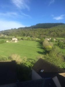 een uitzicht op een groot groen veld met een huis bij Beau studio au calme proche de la cathédrale in Autun