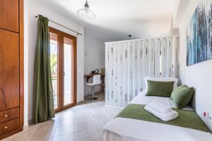 a bedroom with a white bed and a window at Aegeon Hotel in Skopelos Town