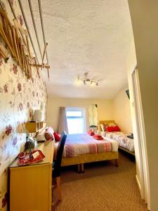 1 dormitorio con 2 camas, escritorio y ventana en Walkden House, en Blackpool