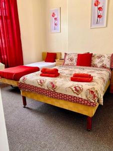 1 dormitorio con 2 camas y cortinas rojas en Walkden House en Blackpool