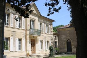 圣让德布莱Malis Castera Le Petit Château的一座大型石头建筑,上面设有阳台