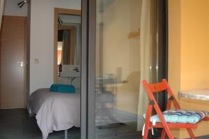 Habitación con cama y puerta de cristal con silla en El Terrat Sobre el Mercat, en La Seu d'Urgell