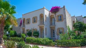 een groot wit gebouw met bloemen erop bij Museum Resort Spa in Bodrum City