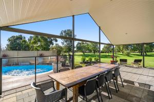 a large patio with a wooden table and chairs at The Lodge - Dunsborough in Dunsborough