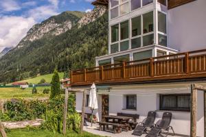 a house with a balcony with a table and chairs at Ottohof - Feldblick in Colle Isarco