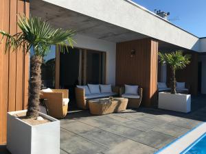 un patio con sillas y palmeras junto a una piscina en Bryza Morska, en Świnoujście