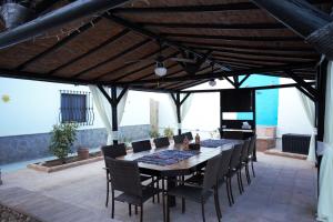 a dining room with a table and chairs on a patio at Casa de las Montañas in Villanueva del Trabuco