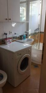 uma casa de banho com uma máquina de lavar roupa e um lavatório em Apartman Mare em Bosanski Novi