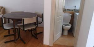 uma pequena mesa e cadeiras num pequeno quarto com WC em Apartman Mare em Bosanski Novi