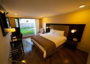 a bedroom with a large bed and a window at Quindeloma Art Hotel & Gallery in Riobamba