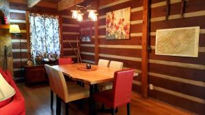 a dining room with a wooden table and red chairs at The Mountain Forager Cabin, Whitewater Rafting, Polar Express, Hot Tub, Home Gym, SMNP, SM Railroad in Bryson City