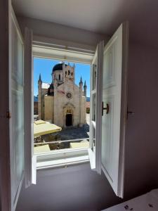 une fenêtre ouverte avec vue sur une église dans l'établissement Apartment Old town Milica, à Herceg-Novi