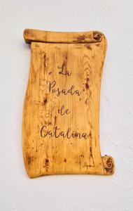a wooden sign on a wall with the writing on it at Preciosa casa de pueblo entre Ronda y Setenil La Posada de Catalina in Montecorto