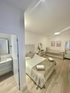 a white bedroom with a bed and a television at Bilbao Azkuna Home Centro EBI01832 in Bilbao