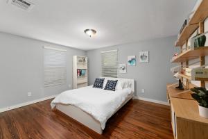 a bedroom with a white bed and wooden floors at New! Entire House, 5 Minutes from downtown in San Marcos