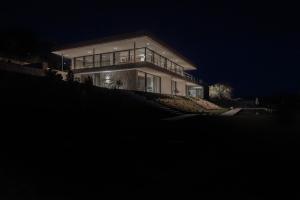 una casa grande en una colina por la noche en Monte Piccolo B&B, en Buje