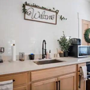 a kitchen with a sink and a welcome sign on the wall at Family Vacation Home in Tampa, Florida in Tampa +3 photos