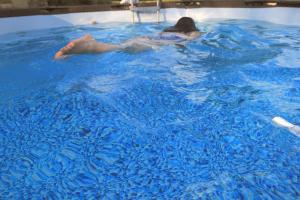 a person swimming in a pool of blue water at Hospedería El Pico del Fraile in Cobreros