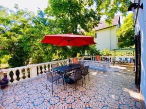 布達佩斯的住宿－布達侯姆公寓，露台上的一张桌子和一把红色遮阳伞