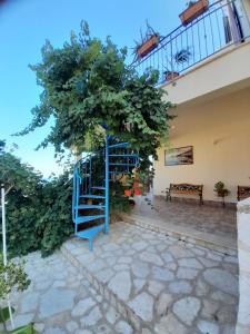 a blue spiral staircase next to a tree at Verdemare in Macari
