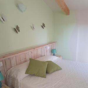 - un lit blanc avec 2 oreillers verts dans l'établissement La casetta di noah, à Carentino