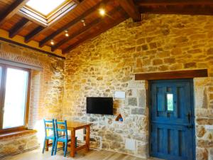 a room with a table and a tv on a stone wall at Precioso apartamento en plena naturaleza in La Cavada