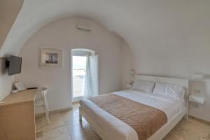 a bedroom with a bed and a desk and a window at MoMa B&B Molfetta Mare in Molfetta