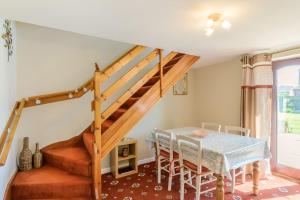 a dining room with a table and a staircase at Westwing in Yoxall