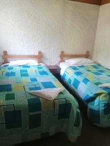 dos camas sentadas una al lado de la otra en una habitación en Posada Montaña del Quetzal, en Cobán