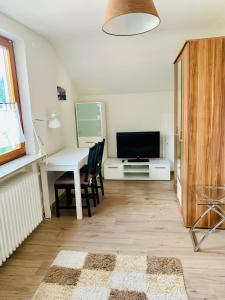 a living room with a table and a television at Villa Goncalves, Komplette Wohnung mit Parkplatz und Wallbox vor der Tür in Calw