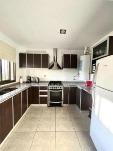 een keuken met bruine kasten en een fornuis met oven bij Luminoso departamento en zona residencial in Mendoza