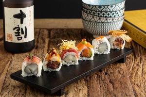 a black plate of sushi and a bottle of wine at Sirena Boutique Hotel in Gabicce Mare