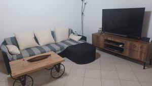 sala de estar con sofá y TV de pantalla plana en VIEW OF CASTLE en Monemvasia